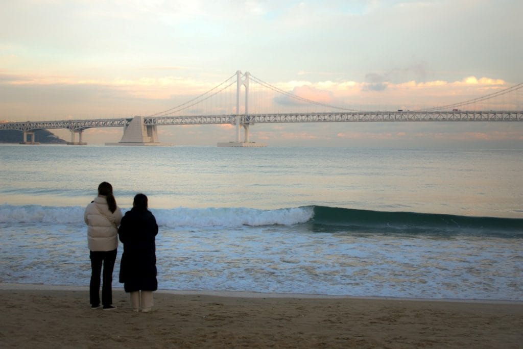 Deux femmes de dos regardent la mer sur la plage de Gwangalli à Busan